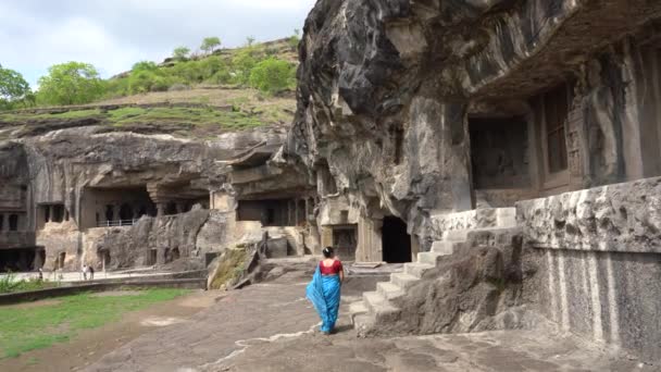 女性観光客はエローラ洞窟を探索し それは世界とユネスコの世界遺産の最大のロックカットされた洞窟の複合体の1つです — ストック動画
