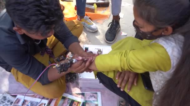 Alirajpur Madhya Pradesh India March 2022 バガゴリア ハート フェスティバルとしても知られているバガゴリア部族の祭典で女性の手でタトゥーを作るタトゥーアーティスト — ストック動画