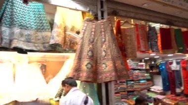 AGRA, INDIA, 23 Ağustos 2022: Jama Mescidi yakınlarındaki Chandni Chowk, Delhi, Hindistan 'da renkli giyim mağazaları, binalar ve rickshaws ile turist, yerel halk ve işlek pazar caddeleri