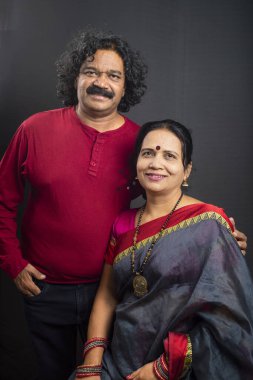 Gri arka planda mutlu Hintli çift.