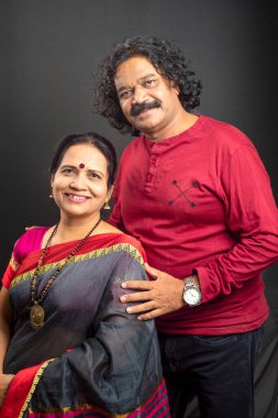 Gri arka planda mutlu Hintli çift.