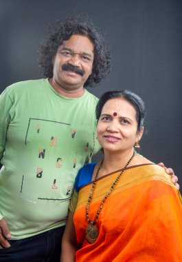 Gri arka planda mutlu Hintli çift.