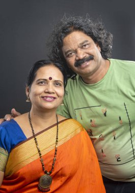 Gri arka planda mutlu Hintli çift.