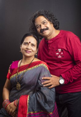 Gri arka planda mutlu Hintli çift.