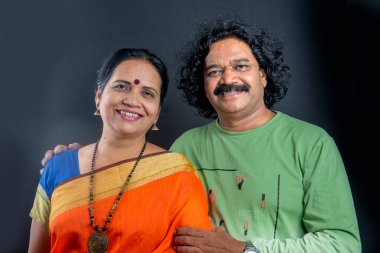 Gri arka planda mutlu Hintli çift.