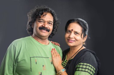 Gri arka planda mutlu Hintli çift.