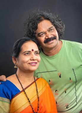 Gri arka planda mutlu Hintli çift.