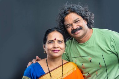 Gri arka planda mutlu Hintli çift.