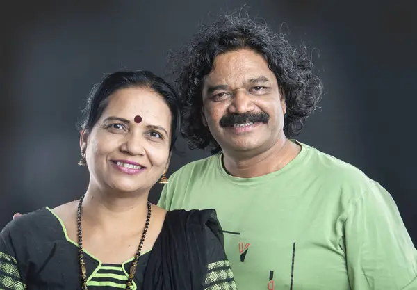 Happy Indian couple on grey background.