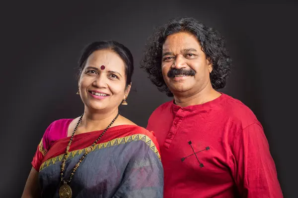 Happy Indian couple on grey background.