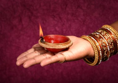 Hindistan 'daki Diwali festivalinde yanan toprak lambasını tutan kadın.