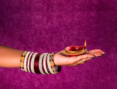 Hindistan 'daki Diwali festivalinde yanan toprak lambasını tutan kadın.