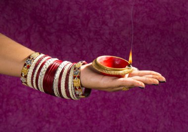 Hindistan 'daki Diwali festivalinde yanan toprak lambasını tutan kadın.