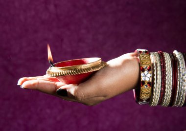 Hindistan 'daki Diwali festivalinde yanan toprak lambasını tutan kadın.