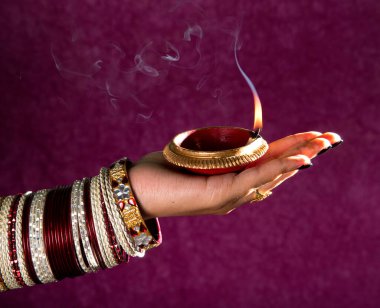 Hindistan 'daki Diwali festivalinde yanan toprak lambasını tutan kadın.