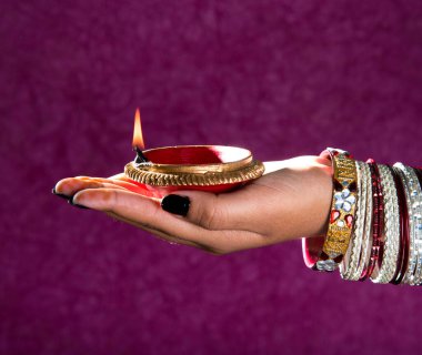 Hindistan 'daki Diwali festivalinde yanan toprak lambasını tutan kadın.