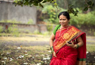 Açık havada geleneksel giysiler içindeki mutlu Hintli kadın..
