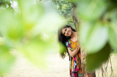 Mutlu Hintli kadın banyan ağacının yanında ve kök salıyor..