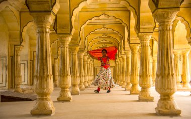 Amber Fort, Jaipur, Rajasthan, Hindistan 'daki Sütunlar Odasında dans eden genç bayan turist UNESCO Dünya Mirası Bölgesi.