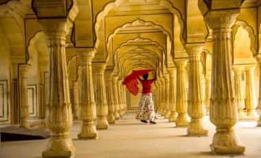 Amber Fort, Jaipur, Rajasthan, Hindistan 'daki Sütunlar Odasında dans eden genç bayan turist UNESCO Dünya Mirası Bölgesi.