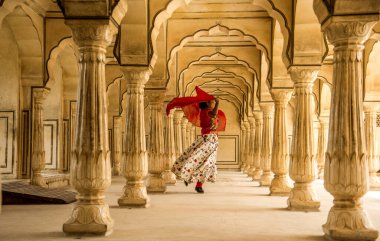 Amber Fort, Jaipur, Rajasthan, Hindistan 'daki Sütunlar Odasında dans eden genç bayan turist UNESCO Dünya Mirası Bölgesi.
