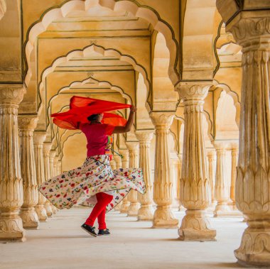 Amber Fort, Jaipur, Rajasthan, Hindistan 'daki Sütunlar Odasında dans eden genç bayan turist UNESCO Dünya Mirası Bölgesi.