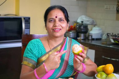 Elinde taze portakal tutan güzel bir Hintli kadın sağlıklı beslenme konsepti..