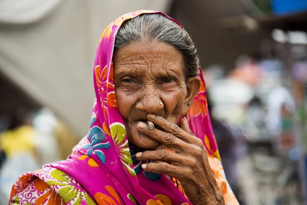 Old age woman smoking Indian handmade cigarette.