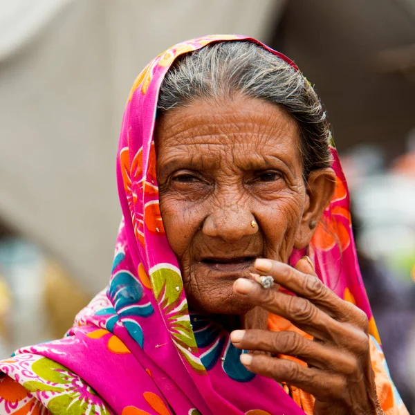 Old age woman smoking Indian handmade cigarette.