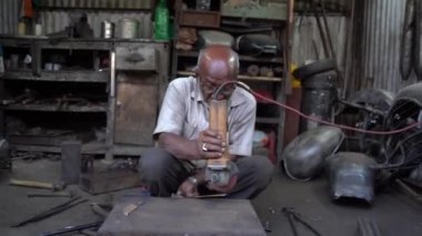 NAGPUR, MAHARASHTRA, INDIA, 29 Aralık 2022: Sokak atölyesinde çalışan garaj işçisi