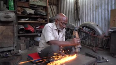 NAGPUR, MAHARASHTRA, INDIA, 29 Aralık 2022: Sokak atölyesinde çalışan garaj işçisi