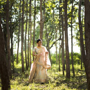 Ormanda geleneksel gelinlik içinde güzel Hintli gelin