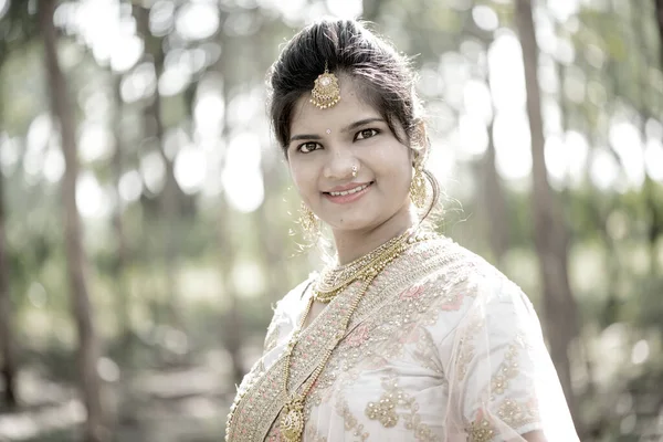 Beautiful Indian bride in traditional wedding dress at outdoor.