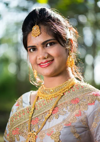 Beautiful Indian bride in traditional wedding dress at outdoor.