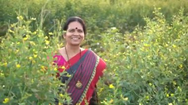Tarım alanında geleneksel giysiler içinde mutlu Hintli kadın.