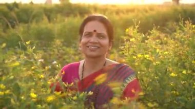 Tarım alanında geleneksel giysiler içinde mutlu Hintli kadın.