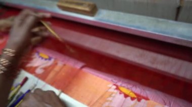 PAITHAN, MAHARASHTRA, INDIA Temmuz 05, 2022: Hindistan Maharashtra, Hindistan 'da bir el dokuma tezgahında saf ipek iplik ve dizayn kullanarak Paithani sarisi dokuan kadın.