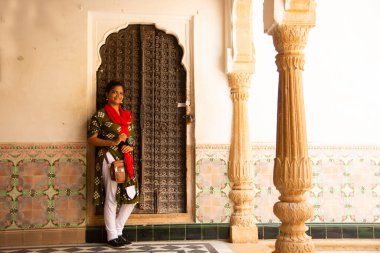 Eski ahşap kapının önündeki kadın turist Jaisalmer, Hindistan