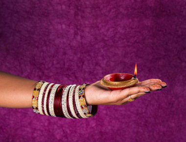 Hindistan 'daki Diwali festivalinde yanan toprak lambasını tutan kadın.