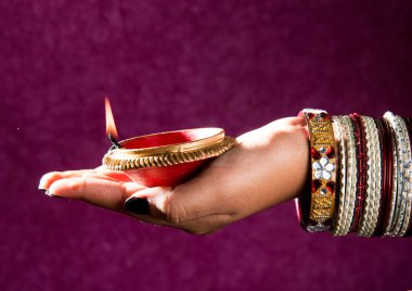 Hindistan 'daki Diwali festivalinde yanan toprak lambasını tutan kadın.