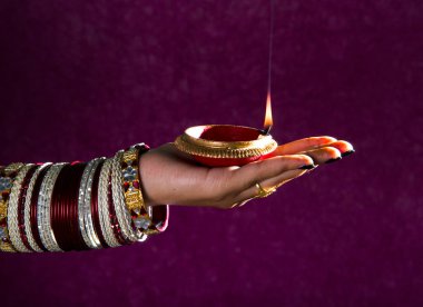 Hindistan 'daki Diwali festivalinde yanan toprak lambasını tutan kadın.