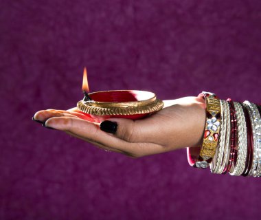 Hindistan 'daki Diwali festivalinde yanan toprak lambasını tutan kadın.