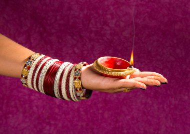 Hindistan 'daki Diwali festivalinde yanan toprak lambasını tutan kadın.