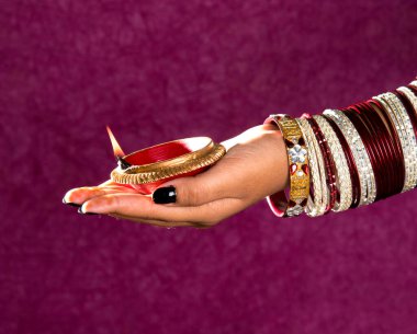 Hindistan 'daki Diwali festivalinde yanan toprak lambasını tutan kadın.