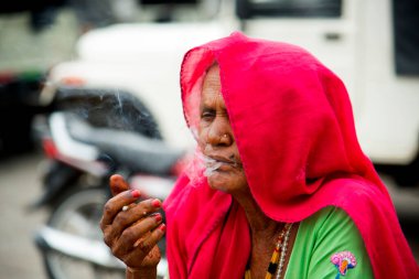 El yapımı Hint sigarası içen yaşlı bir kadın..