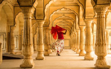 Amber Fort, Jaipur, Rajasthan, Hindistan 'daki Sütunlar Odasında dans eden genç bayan turist UNESCO Dünya Mirası Bölgesi.