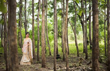 Doğada geleneksel kıyafetler giyen güzel bir gelin portresi..