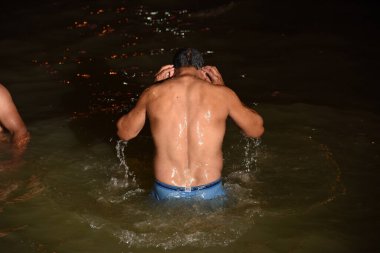 NASHIK, MAHARASHTRA, INDIA, 28 AUGUST 2015 : Hindu devotees bathing in the river, at Kumbh fair.  clipart