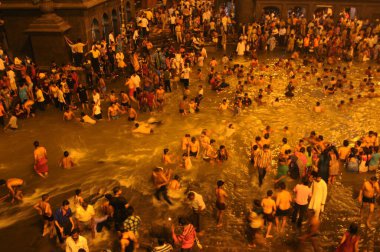 NASHIK, INDIA  29 AUGUST 2015 : Devotees take a holy bath at the in the river during the Simhastha Kumbh Mela. clipart