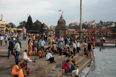 NASHIK, INDIA  29 AUGUST 2015 : Devotees take a holy bath at the in the river during the Simhastha Kumbh Mela. clipart